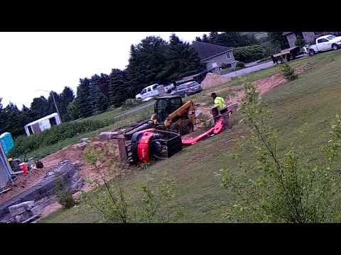 YouTube thumbnail for Excavator tips over from improper load and improper setup